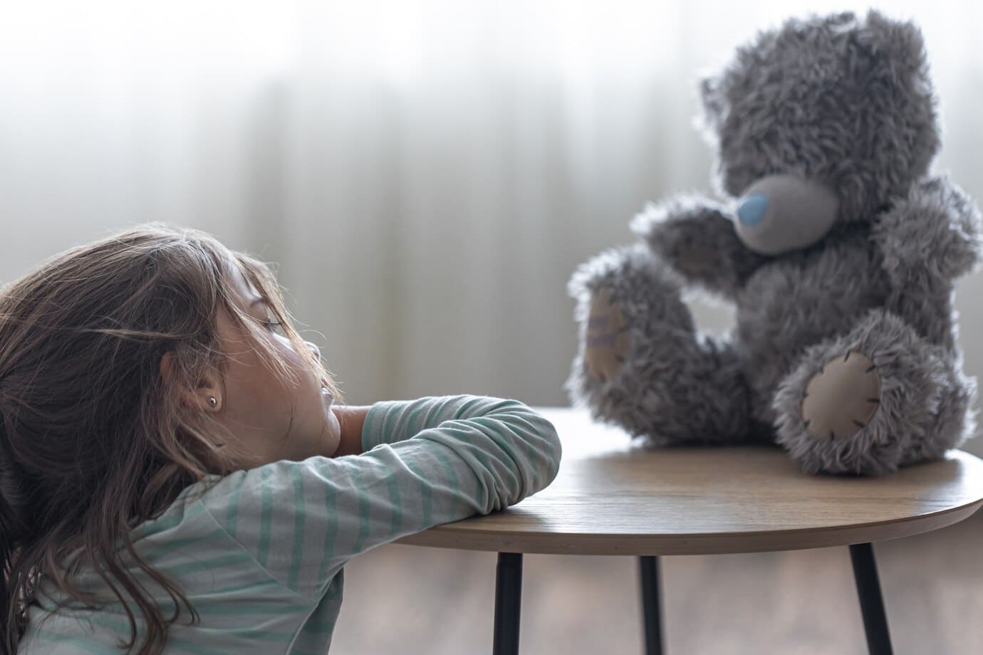 little girl looks at her teddy bear a child with a favorite toy on a blurred background copy space 169016 13786